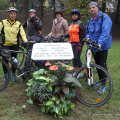 Un gruppo di cicloamatori posa accanto alla targa di Gino Bartali