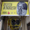 Bellezza in bicicletta, sotto i portici di piazza Palazzo di Città un racconto per immagini sulle due ruote nella storia della città